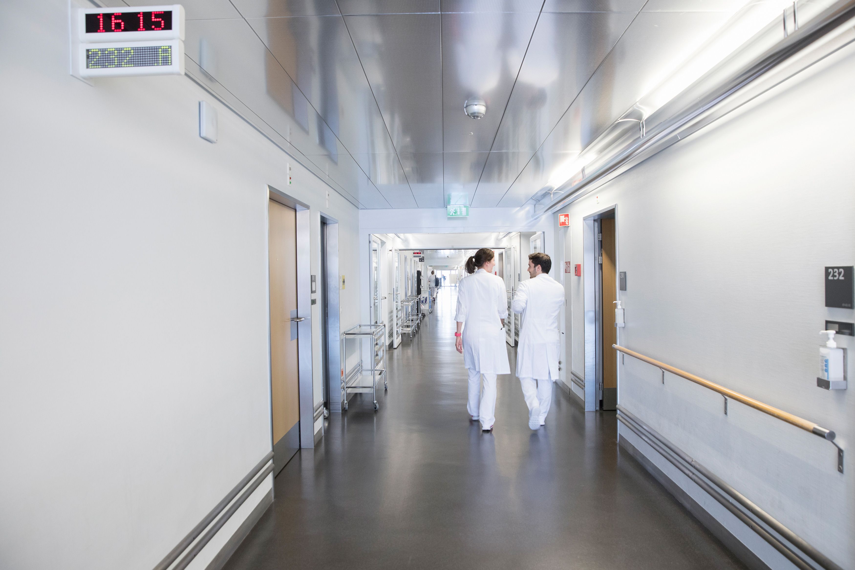 Zwei Ärzte laufen durch einen Gang im Kantonsspital Winterthur und unterhalten sich.